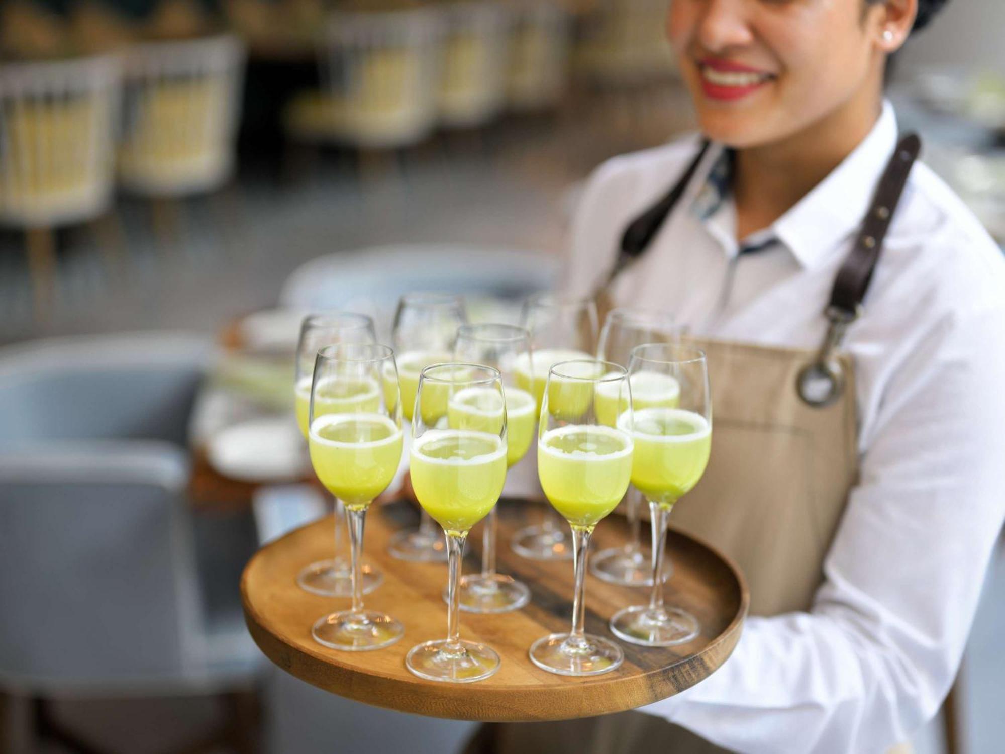 Moevenpick Hotel & Apartments Ghala 马斯喀特 外观 照片 A server holding a tray of cocktails
