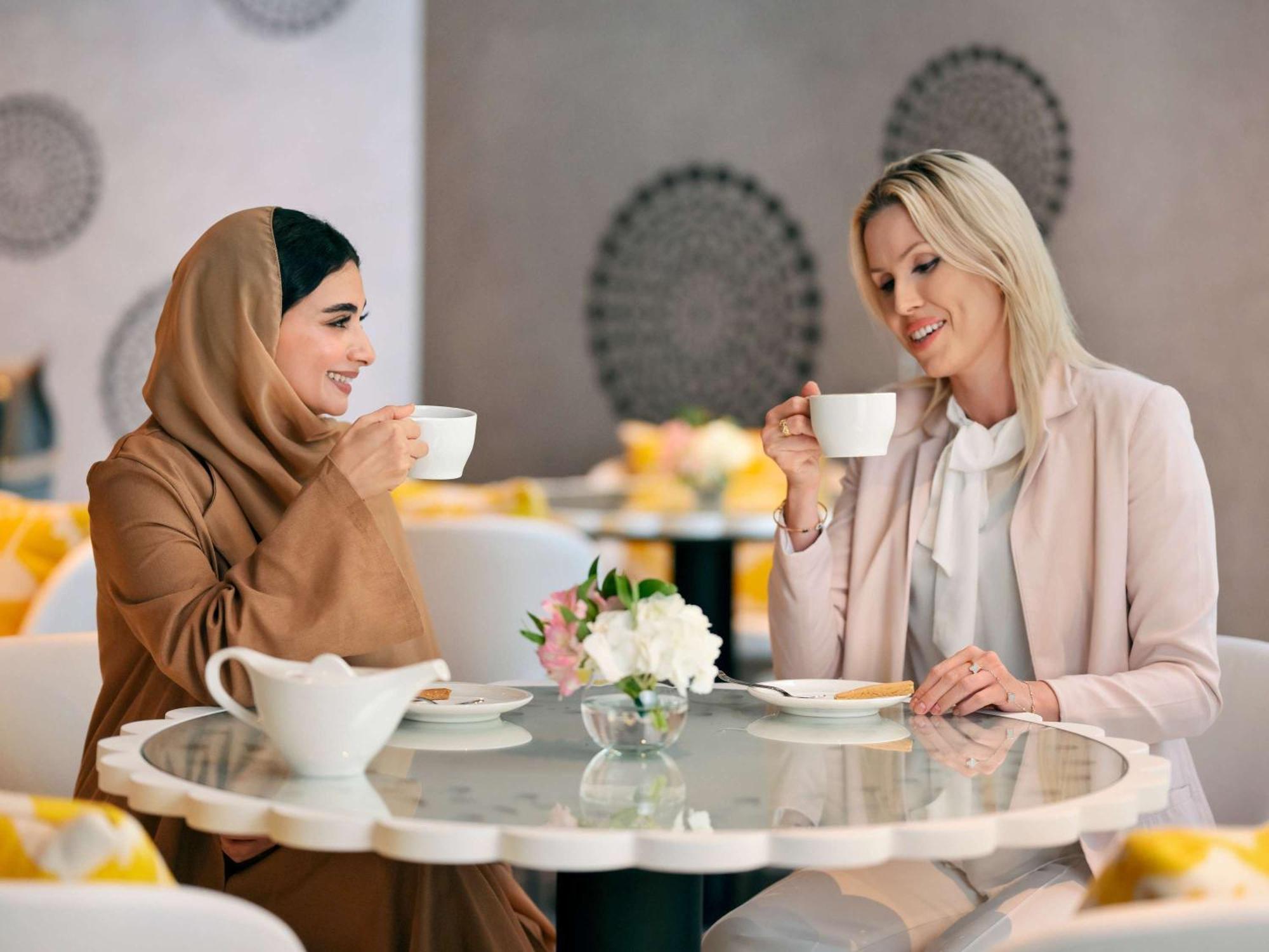 Moevenpick Hotel & Apartments Ghala 马斯喀特 外观 照片 Two women drinking coffee