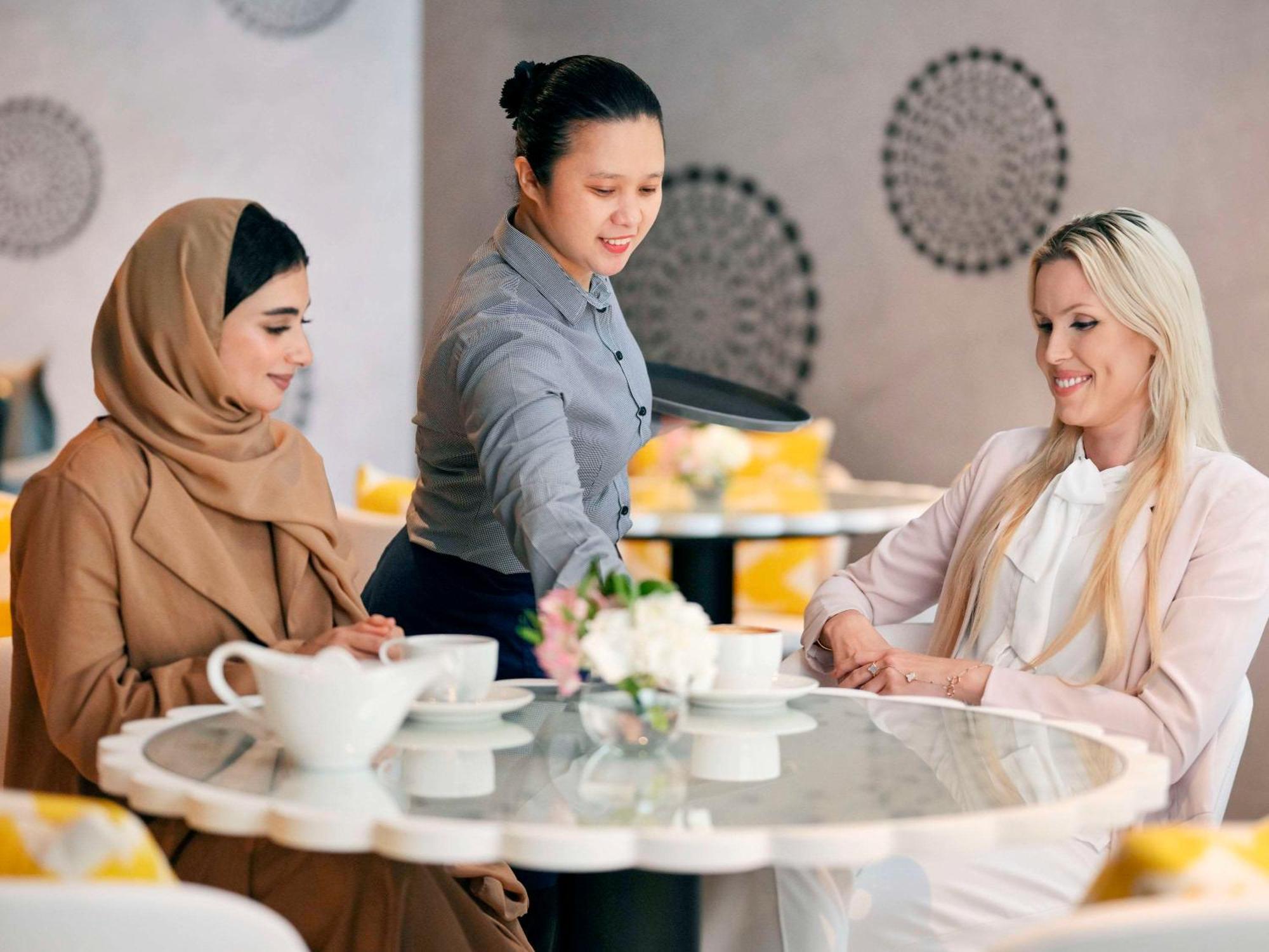 Moevenpick Hotel & Apartments Ghala 马斯喀特 外观 照片 A waitress serving customers